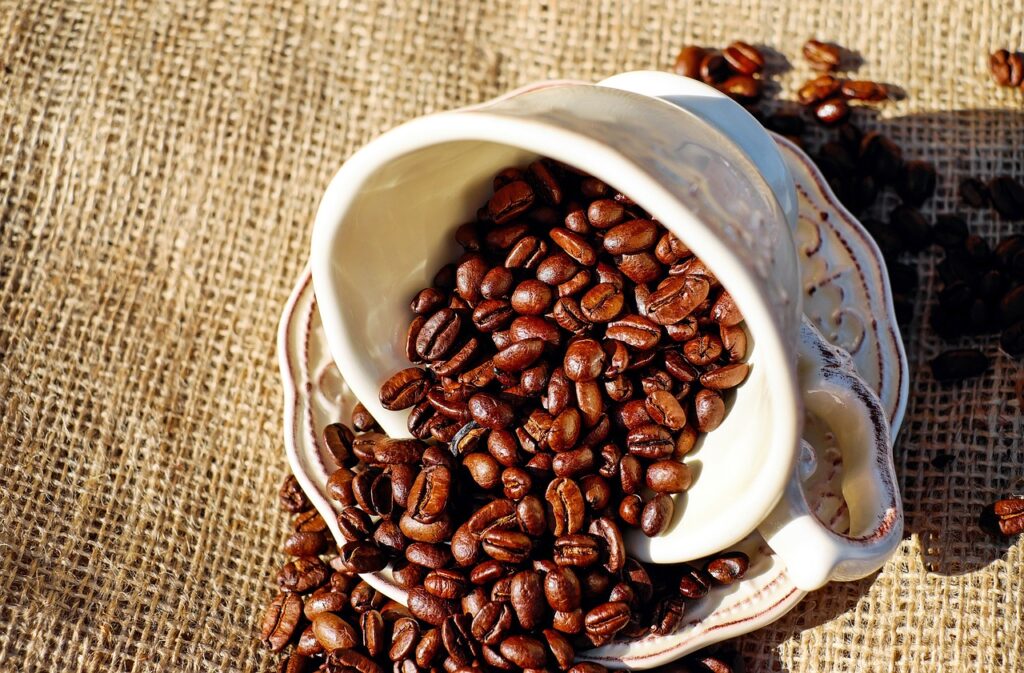 benefícios do café xícara de café com grãos de café dentro